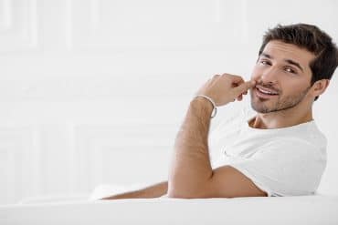 Attractive confident man smriking wearing a white t-shirt
